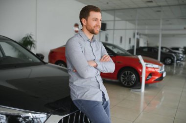 Genç adam yeni bir araç içinde araba Bayilik seçmektir