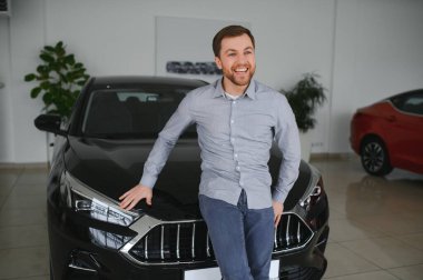 Genç adam yeni bir araç içinde araba Bayilik seçmektir