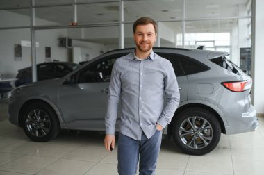 a man chooses a new car for himself walks between the rows in a car dealership.