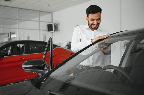 若いインド人が車のディーラーで新しい車を選ぶ — ストック写真