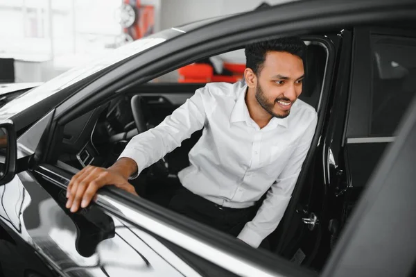 stock image Young man sitting inside new car. Smiling.