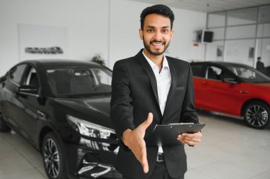 indian cheerful car salesman at showroom