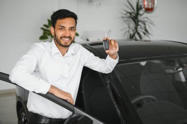 Closeup portrait happy, smiling, young man, buyer showing keys of his new car.