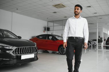 Successful indian businessman in a car dealership - sale of vehicles to customers