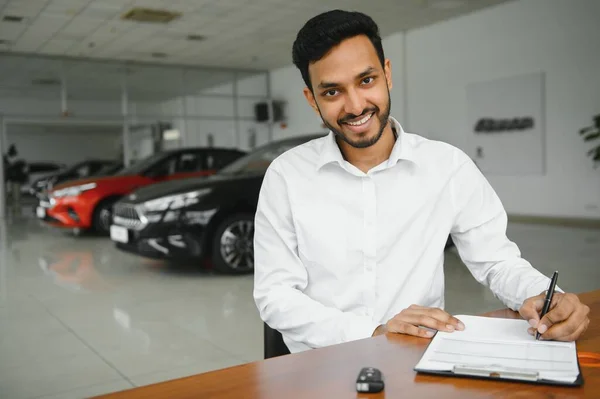 Young Indian Man Signing Documents Car Dealership — Stockfoto