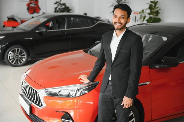 indian cheerful car salesman at showroom