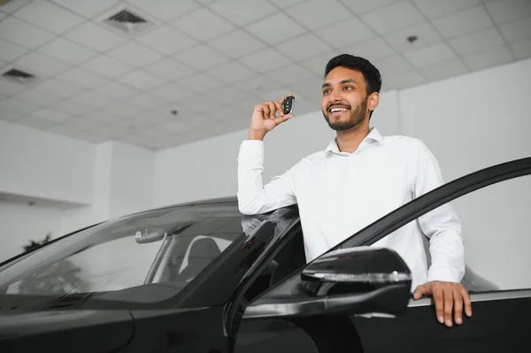 stock image Smiling, friendly indian car seller standing in car salon