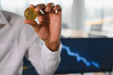 İş adamı kripto tüccar yatırımcı analisti elinde altın Bitcoin ile kripto para satın alıyor hisse senedi piyasası veri yatırımı risklerini analiz ediyor online ticaret mobil uygulaması konseptini kullanarak