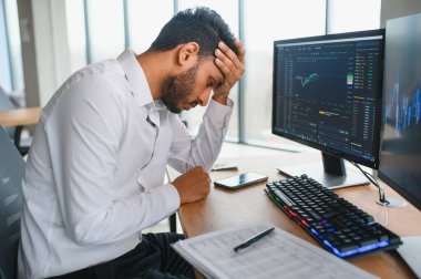 Akıllı Hintli kripto tüccarı, yatırımcı, analist bilgisayar ve akıllı telefon kullanarak dijital kripto döviz borsasını, borsa grafiklerini, yatırım yapmayı düşünme ve fon risklerini analiz ediyor..