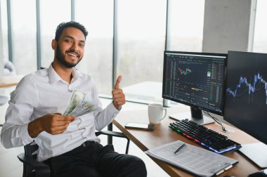 Düşünceli, konsantre Hintli iş adamı yatırımcı yönetici bilgisayar kullanıyor, web sitesinde veri pazarını analiz ediyor ve dizüstü bilgisayara bakarak web araştırması yapıyor.