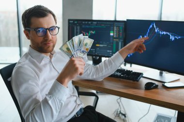 Holding Dollar bills in the stock market. Investors counting money after making it big on the stock market. becoming rich and wealthy. online stock market information