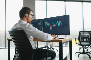 Successful trader in formalwear checking cryptocurrency information data on finance market graph, working in office.