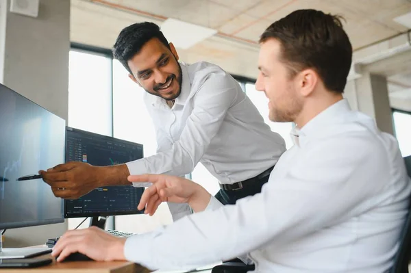 stock image Two diverse crypto traders brokers stock exchange market investors discussing trading charts research reports growth using pc computer looking at screen analyzing invest strategy, financial risks