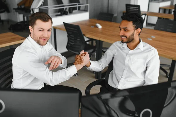 stock image Two men traders sitting at desk at office together monitoring stocks data candle charts on screen analyzing price flow smiling cheerful having profit teamwork concept.