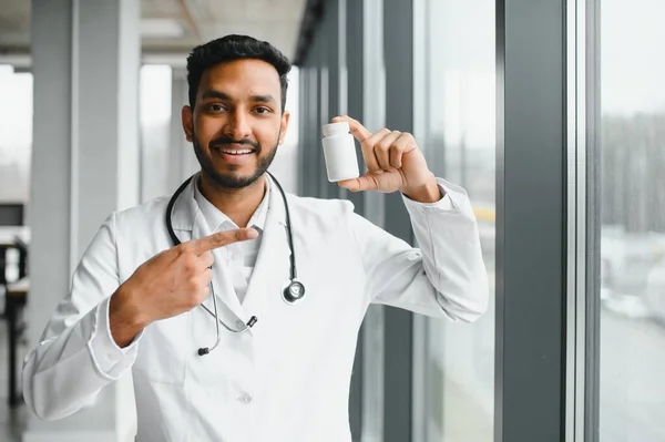 Handsome Indian Male Doctor Holding Empty White Blank Dropper Bottle — Zdjęcie stockowe