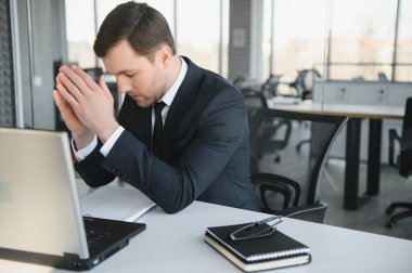 Stresli ve endişeli bir iş adamı portresi. Aşırı çalışan iş adamı görünümlü evraklar modern parlak ofiste baskı altında ve sıkı teslim tarihi altında çalışıyor..