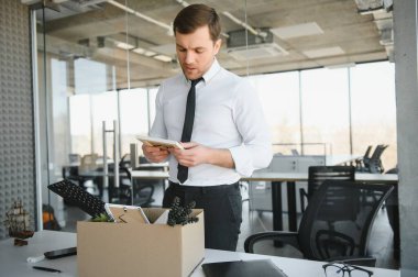 Hüzünlü Kovma. Ofis çalışanı eşyalarını karton kutuya koyup ofisten ayrılmasına izin ver. İşgücü azaltma, küçültme, yeniden yapılanma, yeniden yapılanma, dış kaynak kullanımı. Kitle İşsizlik Piyasası Krizi.
