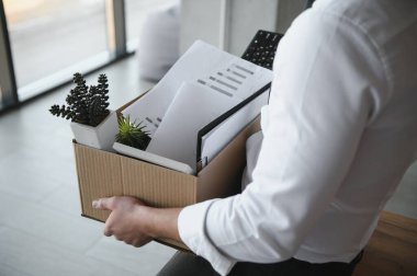 Ofis Toplantısı sırasında karton kutu taşıyan bir iş adamının yakın çekimi.