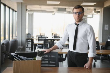 Sad Fired. Let Go Office Worker Packs His Belongings into Cardboard Box and Leaves Office. Workforce Reduction, Downsizing, Reorganization, Restructuring, Outsourcing. Mass Unemployment Market Crisis.