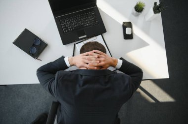 Depresyondaki genç iş adamının el ele tutuşması, sorunu var, masada bir dizüstü bilgisayar. Adamın biri bir işte hata yapmış..
