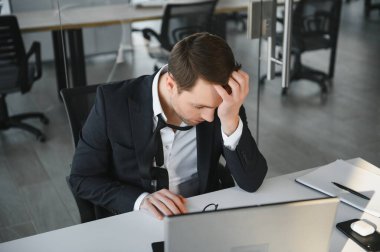 Takım elbiseli ciddi bir iş adamı çevrimiçi haber okumayı düşünüyor ya da bilgisayar başında iş problemini çözüyordu. Ekrana bakıyor, kafası karışmış yöneticilerin bilgisayar kullanarak borsa risklerini yönetiyordu..