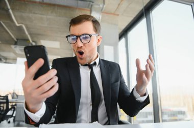 masasında oturan ve çığlık öfkeli üst düzey iş adamı.