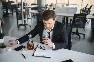 Alcoholism at work. Tired employee drinking alcohol at workplace, can not handle stress