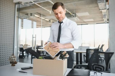 business, firing and job loss concept - fired male office worker with box of his personal stuff