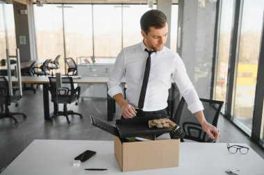 business, firing and job loss concept - fired male office worker with box of his personal stuff