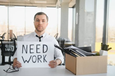 Sad Fired. Let Go Office Worker Packs His Belongings into Cardboard Box and Leaves Office. Workforce Reduction, Downsizing, Reorganization, Restructuring, Outsourcing. Mass Unemployment Market Crisis.