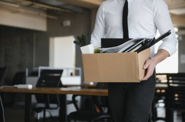Hüzünlü Kovma. Ofis çalışanı eşyalarını karton kutuya koyup ofisten ayrılmasına izin ver. İşgücü azaltma, küçültme, yeniden yapılanma, yeniden yapılanma, dış kaynak kullanımı. Kitle İşsizlik Piyasası Krizi.