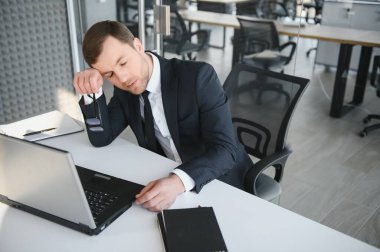 Stresli ve endişeli bir iş adamı portresi. Aşırı çalışan iş adamı görünümlü evraklar modern parlak ofiste baskı altında ve sıkı teslim tarihi altında çalışıyor..