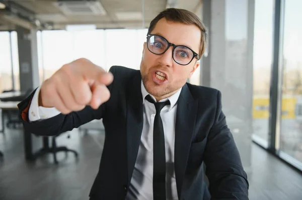 stock image Angry businessman sitting at the table and screaming