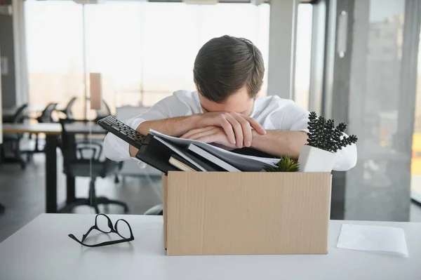 business, firing and job loss concept - fired male office worker with box of his personal stuff