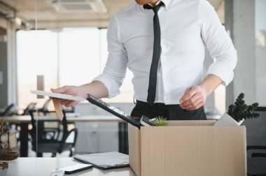 Ofis Toplantısı sırasında karton kutu taşıyan bir iş adamının yakın çekimi.