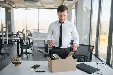 Hüzünlü Kovma. Ofis çalışanı eşyalarını karton kutuya koyup ofisten ayrılmasına izin ver. İşgücü azaltma, küçültme, yeniden yapılanma, yeniden yapılanma, dış kaynak kullanımı. Kitle İşsizlik Piyasası Krizi.