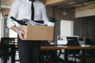 Ofis Toplantısı sırasında karton kutu taşıyan bir iş adamının yakın çekimi.