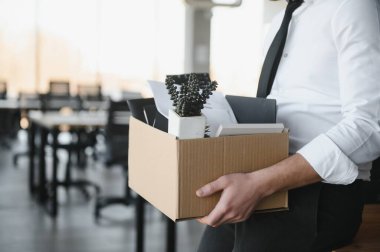 Ofis Toplantısı sırasında karton kutu taşıyan bir iş adamının yakın çekimi.