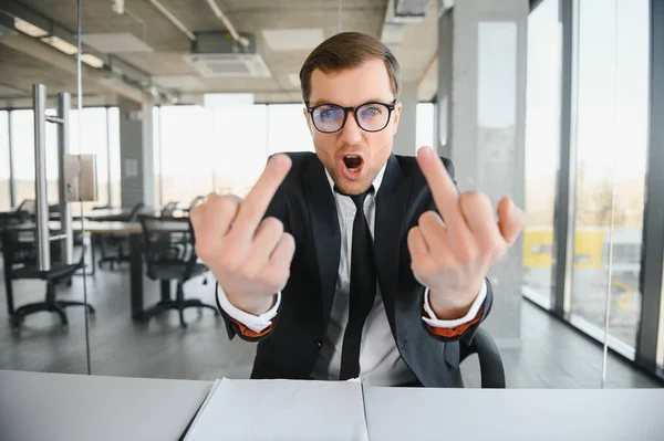 Portrait of angry business man showing double middle fingers.