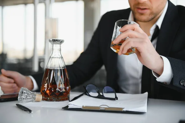 Fatiga Joven Empresario Sentado Lugar Trabajo Sosteniendo Botella Whisky Beber — Foto de Stock