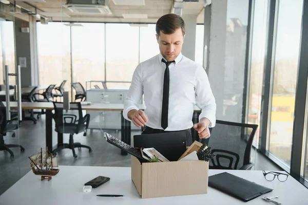 Hüzünlü Kovma. Ofis çalışanı eşyalarını karton kutuya koyup ofisten ayrılmasına izin ver. İşgücü azaltma, küçültme, yeniden yapılanma, yeniden yapılanma, dış kaynak kullanımı. Kitle İşsizlik Piyasası Krizi.