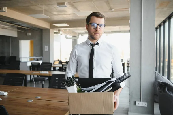 stock image Sad Fired. Let Go Office Worker Packs His Belongings into Cardboard Box and Leaves Office. Workforce Reduction, Downsizing, Reorganization, Restructuring, Outsourcing. Mass Unemployment Market Crisis.