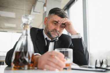 İş yerinde alkol alan yaşlı bir erkek işçi..