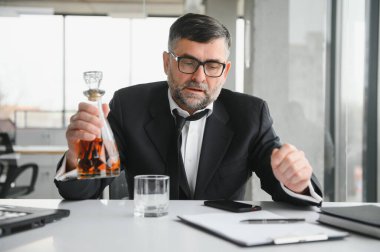 İş yerinde alkol alan yaşlı bir erkek işçi..