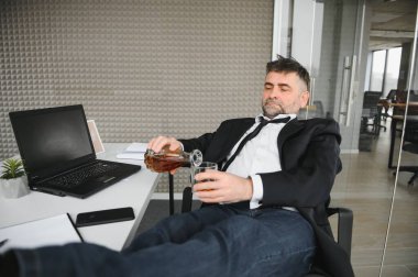 İş yerinde alkol alan yaşlı bir erkek işçi..