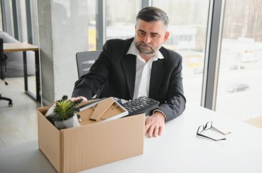 Eski bir çalışan, eşyalarla dolu bir kutuyla ofisten çıkıyor..