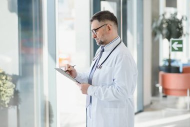 Gri saç uzmanlığı yakışıklı yaşlı doktor hastane portresi.