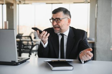 Genç yakışıklı işadamı dizüstü bilgisayar ekranında bağırmak ve mali durumu hakkında rakip yetenekleri, istemci ihtiyaçlarını karşılamak mümkün kıskanç kızgın modern ofis masasında çalışan vurguladı.