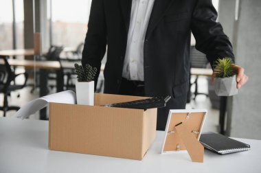 Ofis malzemelerini kutuya koyan üzgün yaşlı işadamı portresi. Emekliler işten emekli olur, çalışanları eve taşır. Yaşam tarzı iş emekliliği, iş bırakma kavramı.