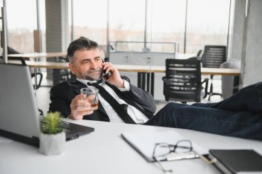 Alcoholism at work. Tired employee drinking alcohol at workplace, can not handle stress.